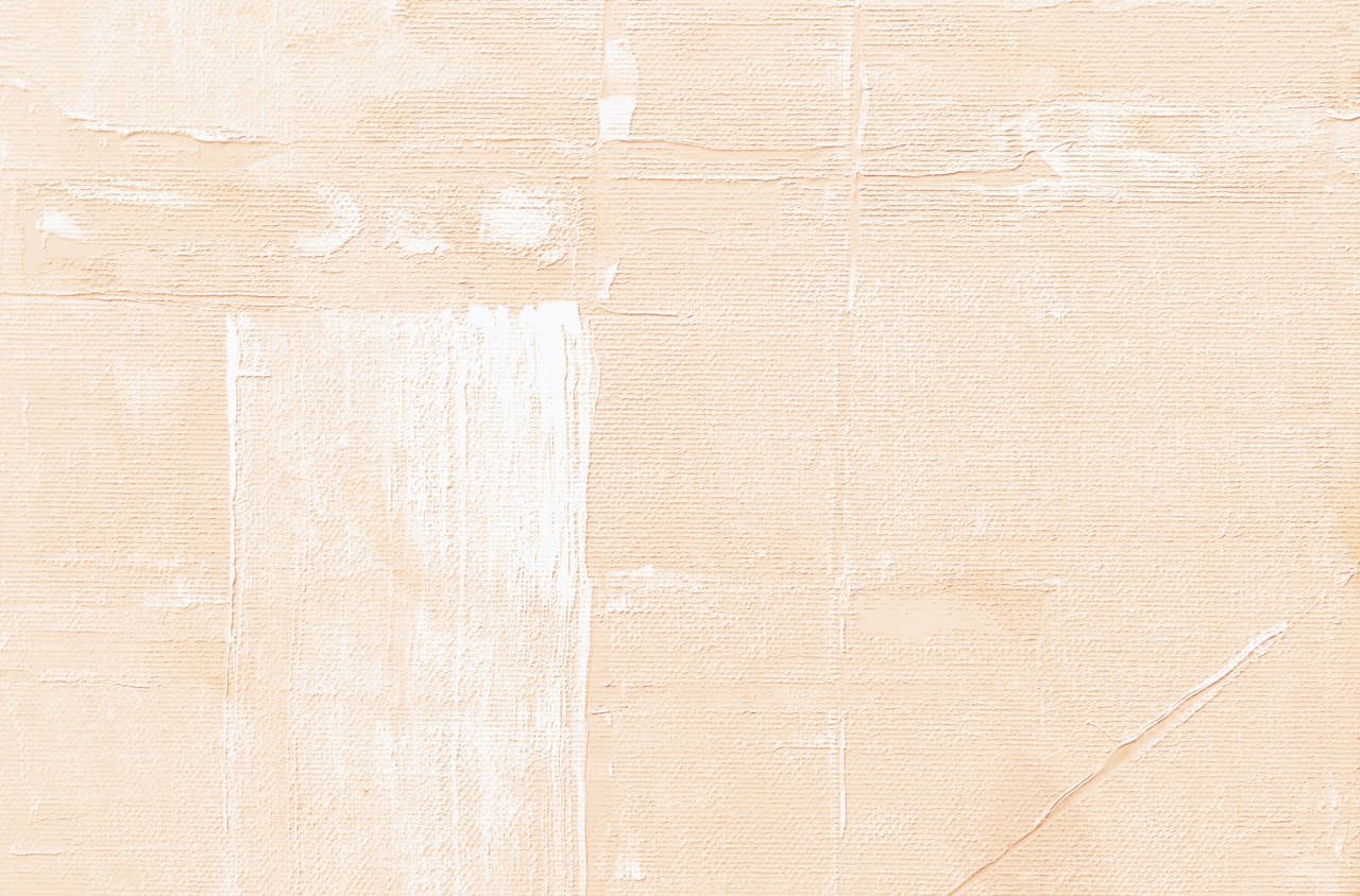 Close-up of a textured beige canvas with brush strokes, perfect for backgrounds and design projects.